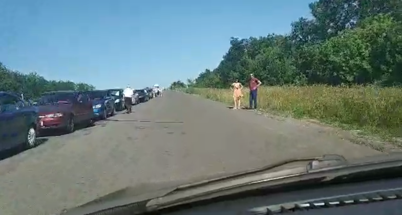 Боевики «ДНР» пропускают в Украину не более 5-6 машин в час, из-за этого на жаре образуются огромные очереди, в которых люди часами стоят под палящим солнцем.