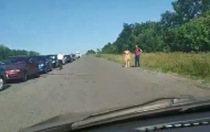 Боевики «ДНР» пропускают в Украину не более 5-6 машин в час, из-за этого на жаре образуются огромные очереди, в которых люди часами стоят под палящим солнцем.