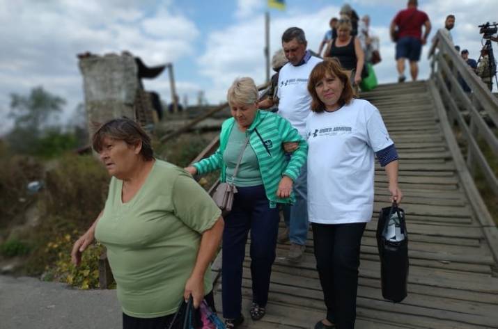 Пенсионерам и людям, которые нуждаются в помощи, будут бесплатно помогать при перемещении по деревянной лестнице на так называемом «провале» моста вблизи КПВВ «Станица Луганская».