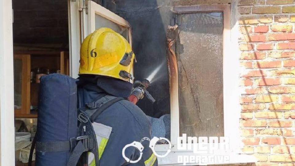 пожежа, пожежник, рятувальник гасить вогонь у будинку