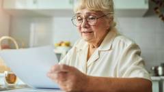пенсіонерка дивиться рахунок на комунальні послуги на пенсії